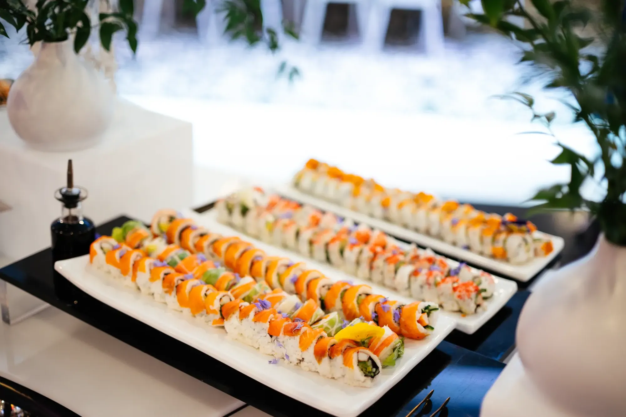 Plateaux de sushis assortis présentés sur une table de buffet.
